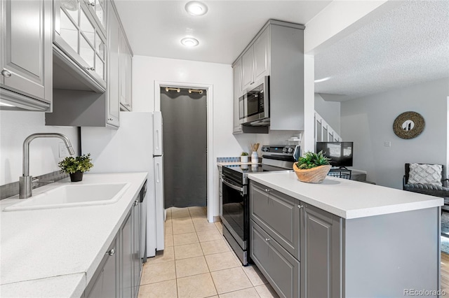 kitchen featuring appliances with stainless steel finishes, gray cabinetry, and sink