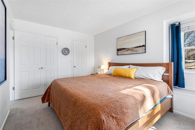 bedroom with a textured ceiling and light carpet