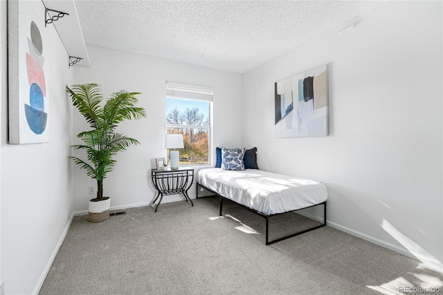 bedroom featuring carpet and a textured ceiling