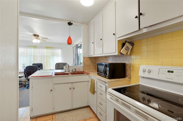 2732 W Archer Pl, Denver, CO 80219 - kitchen featuring white electric stove, black microwave, white cabinetry, light countertops, and a peninsula