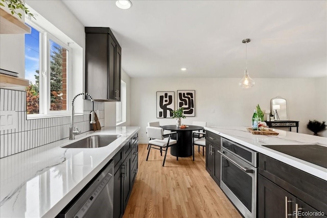 11021 Otis St, Westminster, CO 80020 - kitchen with a sink, appliances with stainless steel finishes, recessed lighting, light wood finished floors, and hanging light fixtures