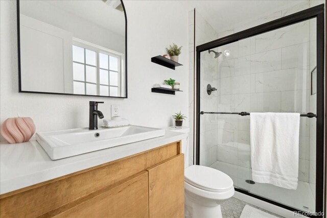 11021 Otis St, Westminster, CO 80020 - bathroom featuring a shower stall, toilet, vanity, and tile patterned floors