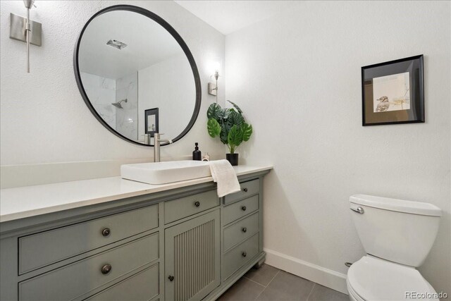 11021 Otis St, Westminster, CO 80020 - bathroom with tile patterned flooring, vanity, toilet, baseboards, and a shower