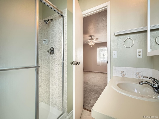 bathroom featuring walk in shower, a textured ceiling, ceiling fan, and sink