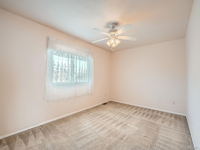 carpeted spare room with ceiling fan