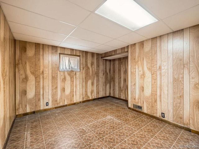 empty room with wooden walls and a drop ceiling