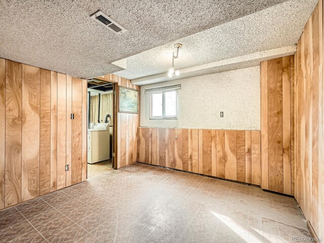 basement with wood walls and washer / dryer