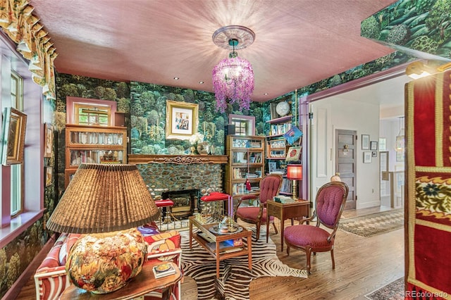 2324 S Columbine St, Denver, CO 80210 - sitting room featuring wallpapered walls, a fireplace, wood finished floors, baseboards, and a chandelier
