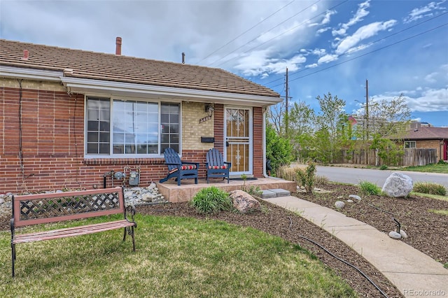 3600 Olive St, Denver, CO 80207 - view of front of house with a porch, brick siding, fence, and a front yard