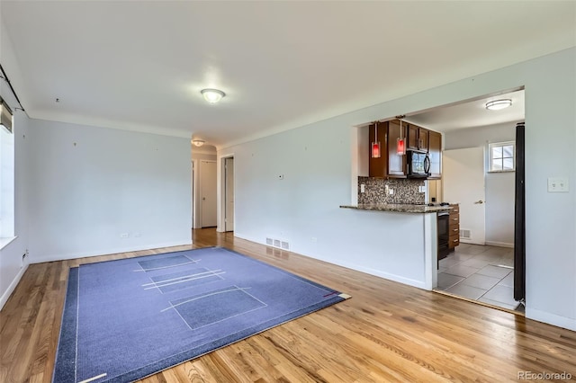 3600 Olive St, Denver, CO 80207 - unfurnished living room with light wood-style floors, baseboards, and visible vents