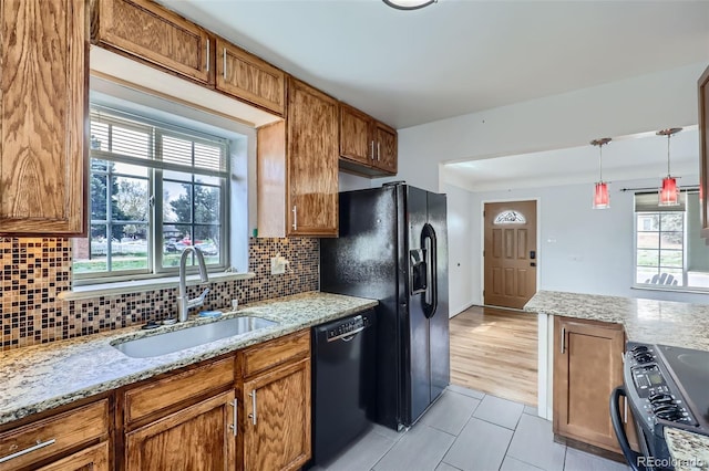 3600 Olive St, Denver, CO 80207 - kitchen with a sink, black appliances, brown cabinets, and light tile patterned flooring