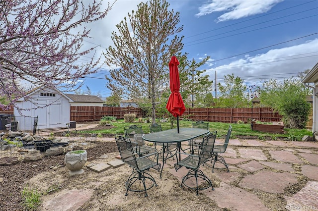 3600 Olive St, Denver, CO 80207 - view of patio with a fenced backyard, an outdoor structure, outdoor dining area, and a shed