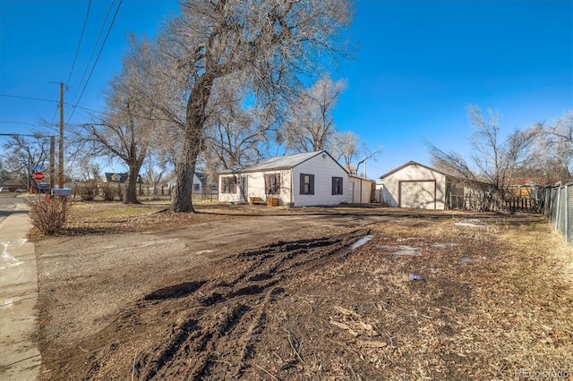 single story home featuring fence and an outdoor structure