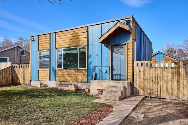 view of front of home with a front lawn and fence