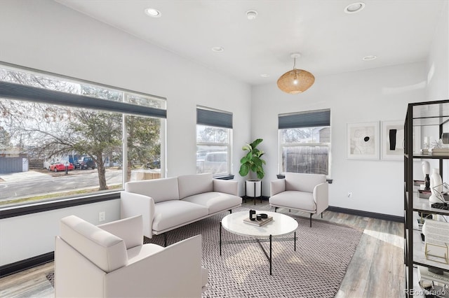 living area with recessed lighting, baseboards, plenty of natural light, and light wood-style flooring