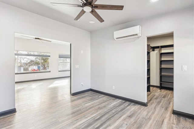 spare room featuring wood finished floors, baseboards, a wall mounted AC, recessed lighting, and ceiling fan