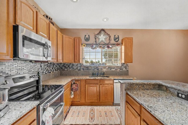 kitchen with light stone countertops, backsplash, and appliances with stainless steel finishes