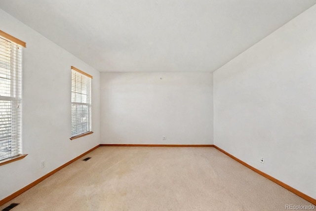 spare room featuring light colored carpet