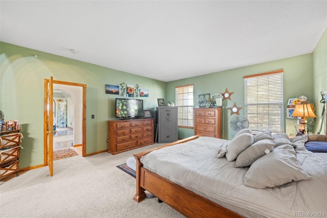 bedroom featuring light carpet and baseboards