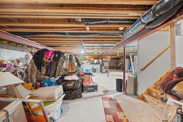 unfinished basement featuring water heater and stairs