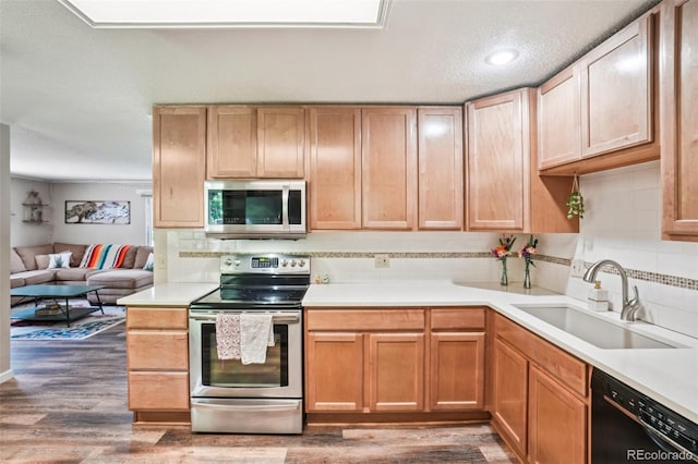 1213 S Taft Hill Rd, Fort Collins, CO 80521 - kitchen with appliances with stainless steel finishes, backsplash, wood finished floors, light countertops, and open floor plan