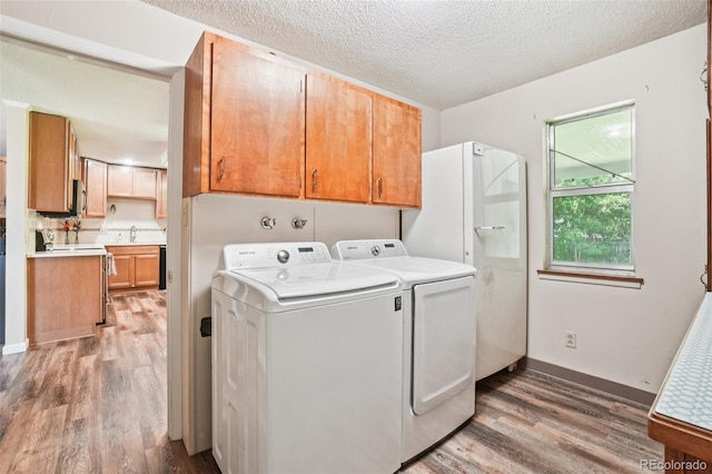1213 S Taft Hill Rd, Fort Collins, CO 80521 - laundry room featuring light wood-type flooring, cabinet space, a textured ceiling, and independent washer and dryer