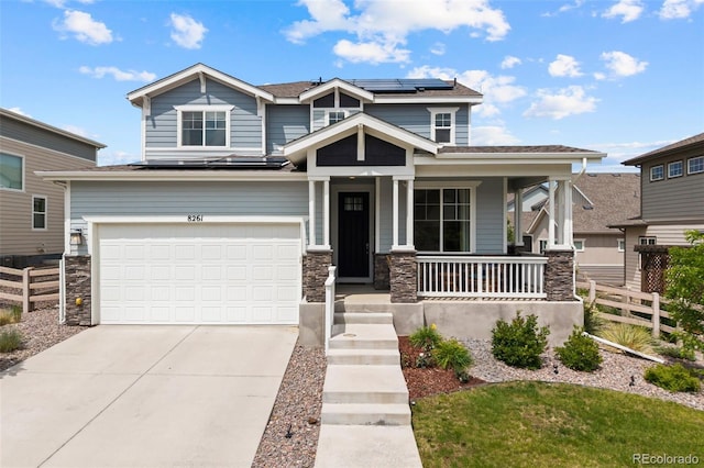 8261 Garden City Ave, Littleton, CO 80125 - craftsman-style home with a porch, concrete driveway, solar panels, an attached garage, and stone siding