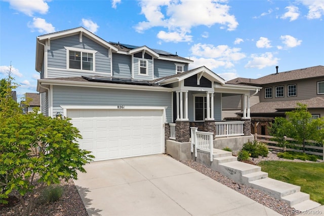 8261 Garden City Ave, Littleton, CO 80125 - view of front of home featuring a porch, roof mounted solar panels, driveway, and an attached garage