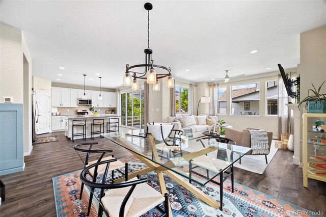 8261 Garden City Ave, Littleton, CO 80125 - dining space featuring dark wood-type flooring, ceiling fan, recessed lighting, a chandelier, and baseboards
