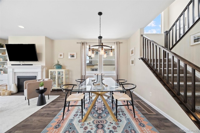 8261 Garden City Ave, Littleton, CO 80125 - dining space with a chandelier, baseboards, dark wood finished floors, stairs, and a fireplace