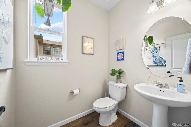 8261 Garden City Ave, Littleton, CO 80125 - bathroom featuring toilet, wood finished floors, baseboards, and a sink