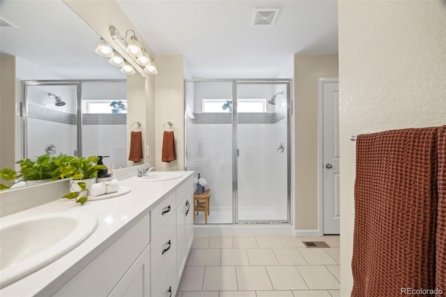 8261 Garden City Ave, Littleton, CO 80125 - bathroom with plenty of natural light, a shower stall, double vanity, and tile patterned floors
