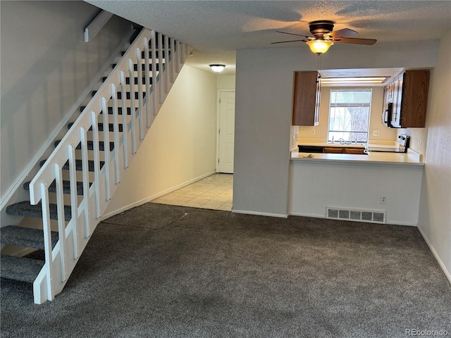 interior space with stove, sink, light carpet, and ceiling fan