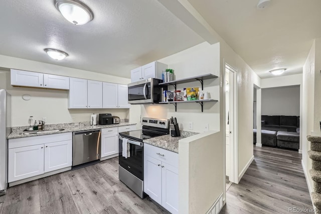 5712 S Lowell Blvd, Littleton, CO 80123 - kitchen with appliances with stainless steel finishes, a sink, light wood-style flooring, white cabinetry, and open shelves