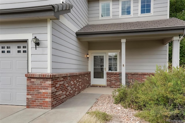 property entrance featuring a porch and a garage