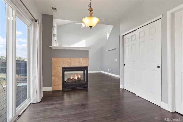 unfurnished living room featuring dark hardwood / wood-style floors and a tile fireplace