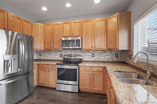 kitchen featuring light stone countertops, tasteful backsplash, stainless steel appliances, sink, and dark hardwood / wood-style floors