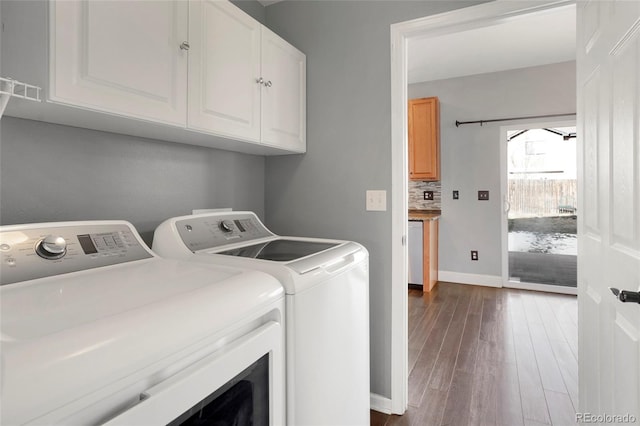 laundry room featuring cabinets, independent washer and dryer, and dark wood-type flooring