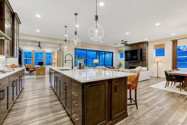 2159 Bellcove Dr, Castle Pines, CO 80108 - kitchen with a ceiling fan, dark brown cabinets, light wood-type flooring, light countertops, and recessed lighting