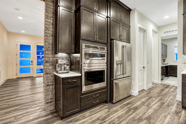 2159 Bellcove Dr, Castle Pines, CO 80108 - kitchen with stainless steel appliances, wood finished floors, dark brown cabinets, light countertops, and recessed lighting