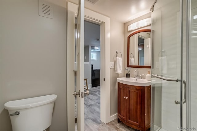 3525 N Alcott St, Denver, CO 80211 - bathroom featuring vanity, wood finished floors, a stall shower, toilet, and baseboards