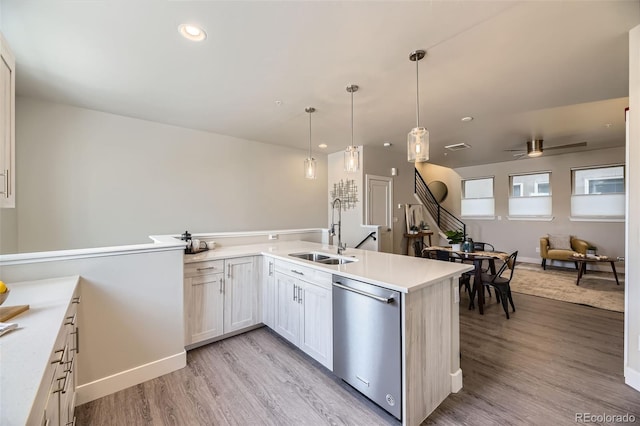 kitchen with pendant lighting, dishwasher, sink, white cabinets, and kitchen peninsula