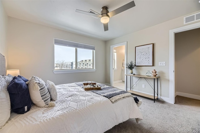 carpeted bedroom with ensuite bathroom and ceiling fan