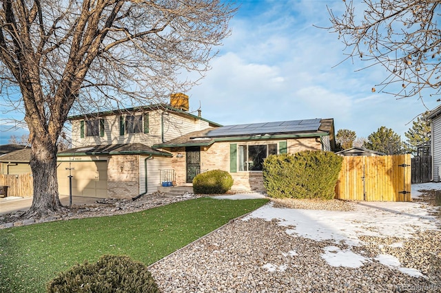 view of front facade featuring a front yard and solar panels