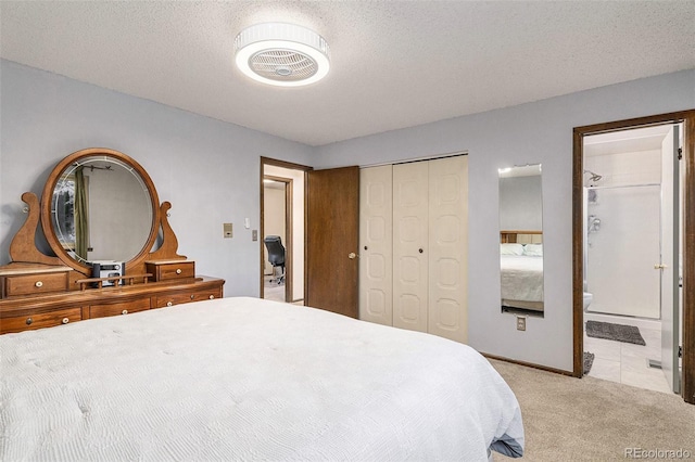 bedroom with light colored carpet, a textured ceiling, ensuite bath, and a closet