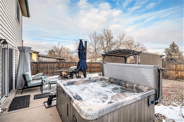 snow covered patio featuring a hot tub