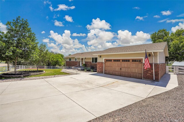 9880 E 157th Ave, Brighton, CO 80602 - ranch-style house with brick siding, an attached garage, and driveway