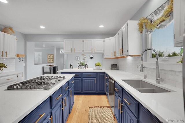 9880 E 157th Ave, Brighton, CO 80602 - kitchen with blue cabinets, stainless steel gas stovetop, a sink, white cabinets, and recessed lighting