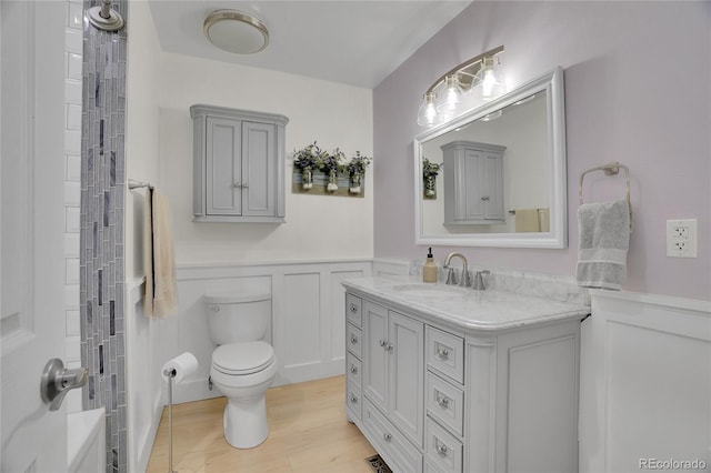 9880 E 157th Ave, Brighton, CO 80602 - full bath featuring wainscoting, vanity, toilet, wood finished floors, and a decorative wall