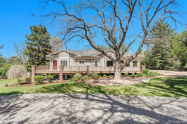 view of front of property with a wooden deck and a front yard